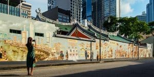 Lady taking photo of mural outside of Thian Hock Keng Temple.