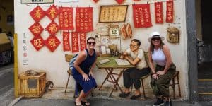 2 tourist posing with The Letter Writer wall mural